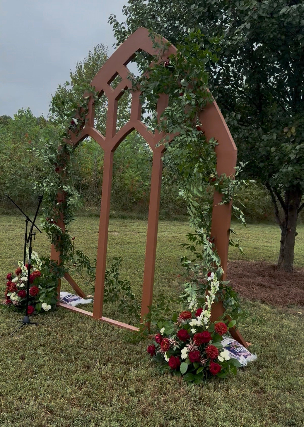Wooden ceremony arch with flowers on the grass