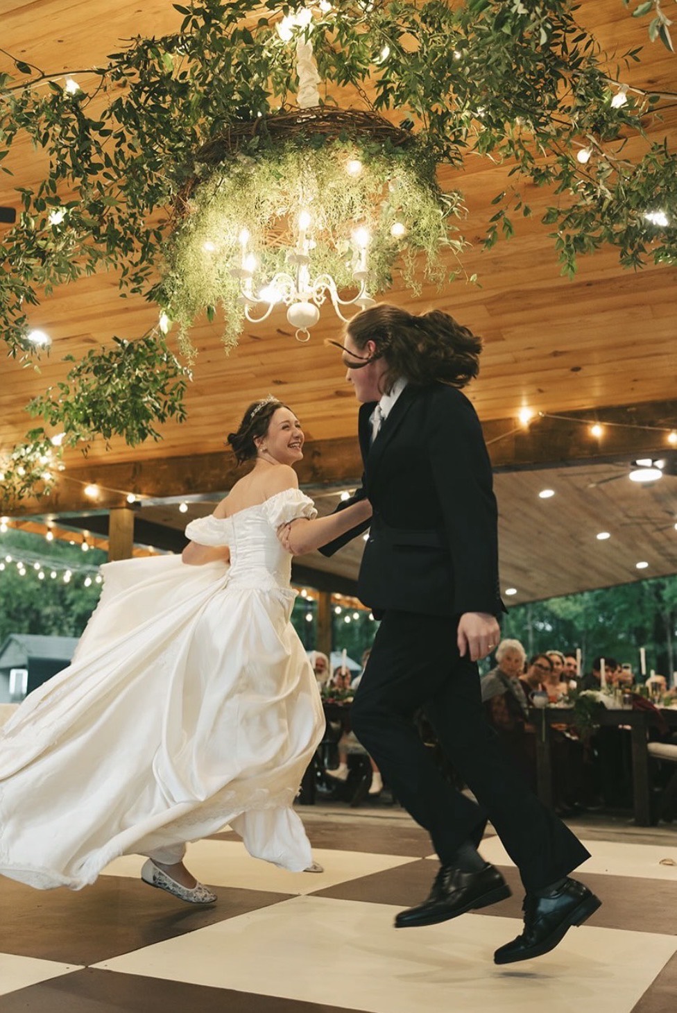 Bride and groom twirling under the chandelier in the Pavilion