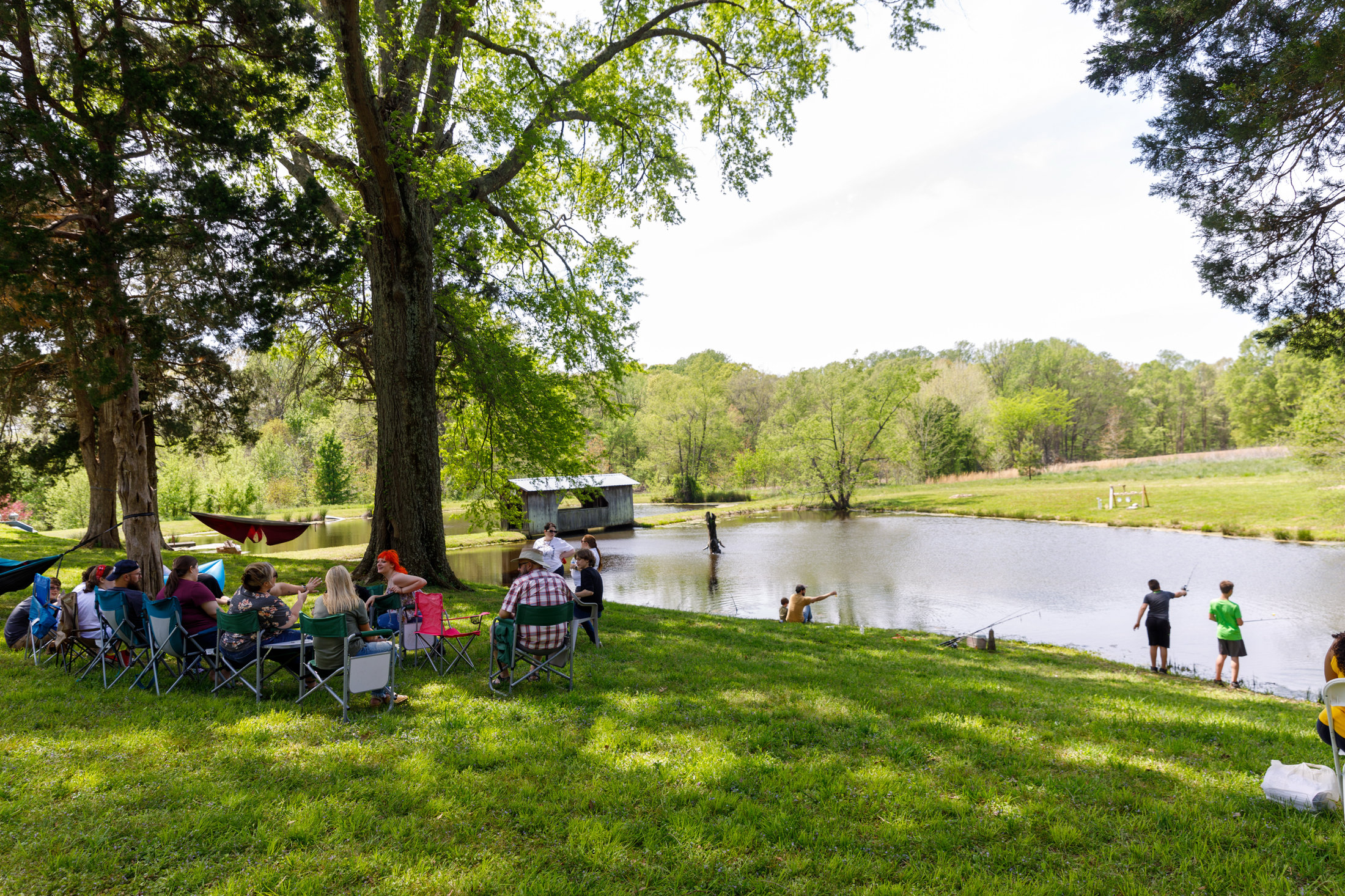 Families gathered on the lawn by the pond