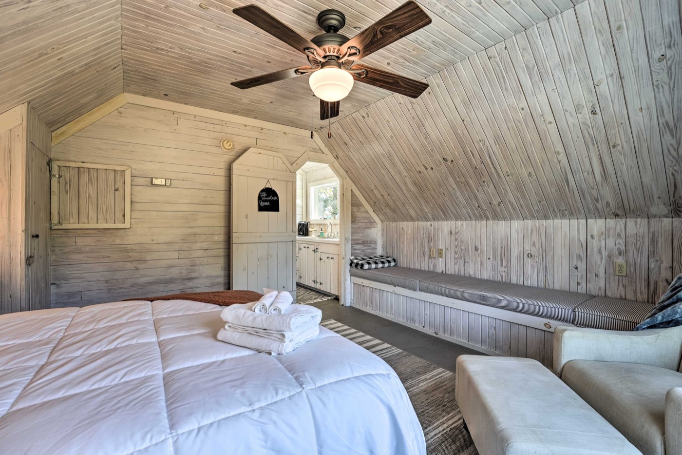 Loft bedroom with a window seat and ceiling fan