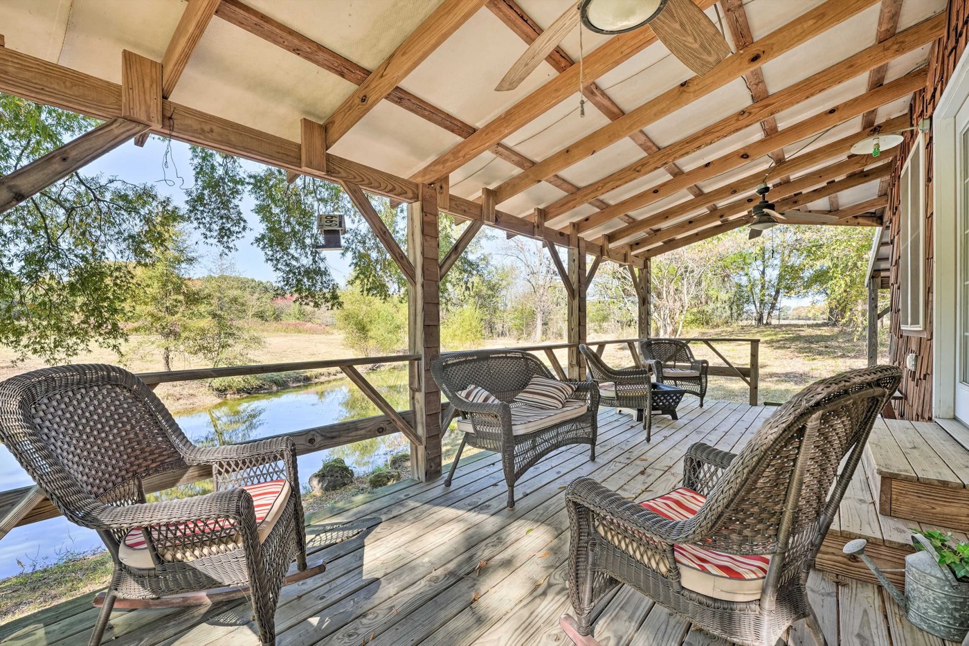 Covered deck with wicker chairs overlooking the pond