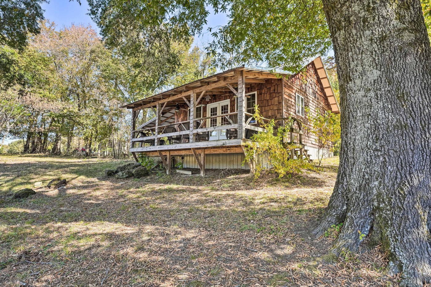 Cabin and deck under large oak trees