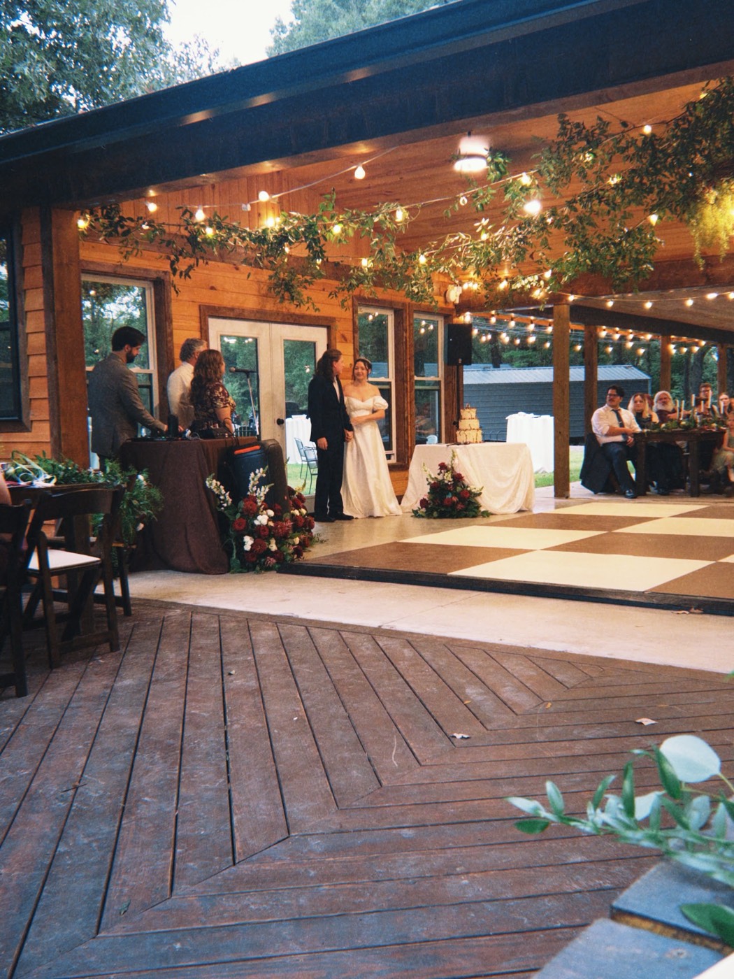 Bride and groom at their reception on the Pavilion deck at dusk